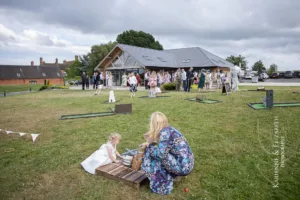 The front view of the wedding barn taken while the wedding guests enjoy the garden lawn games during Blithfield Lakeside Barns Wedding.
