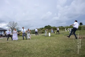 The wedding guests enjoy the garden lawn games during Blithfield Lakeside Barns Wedding.